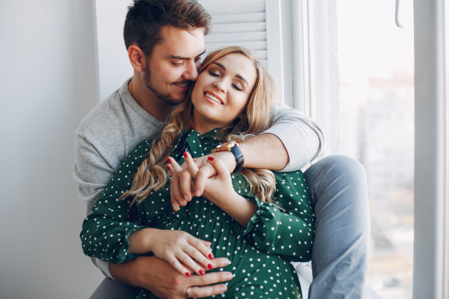 Couple tendrement enlacé près d’une fenêtre