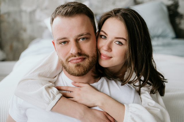 Couple complice enlacé, regardant l’objectif