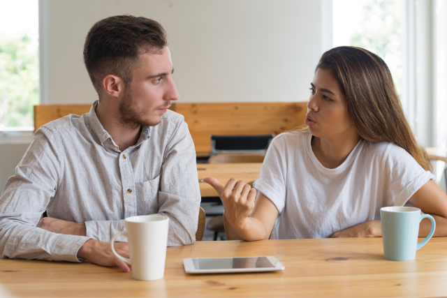 Couple qui dialogue autour d’une table avec deux tasses