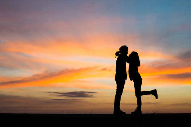 Silhouette d’un couple qui s’embrasse au coucher du soleil