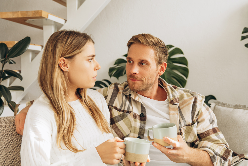 Couple qui discute autour d’un café, la femme l’air pensif