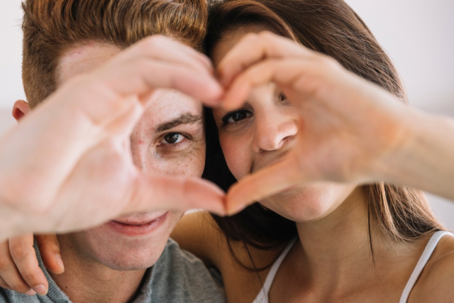 Couple qui forme un cœur avec ses mains