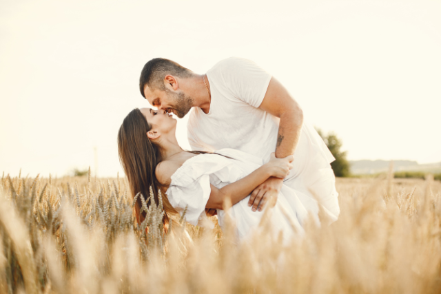 Couple complice qui s’embrasse dans un champ de blé au soleil