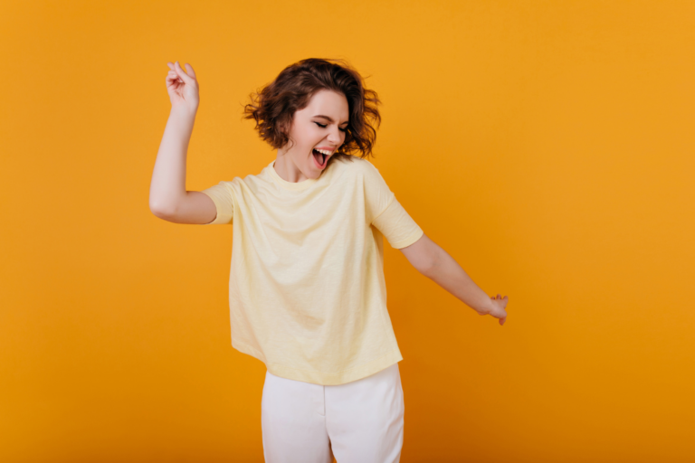 Femme qui danse, heureuse et libre, sur fond orange
